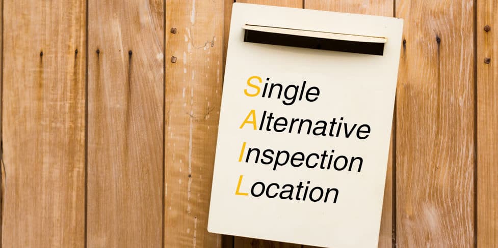 Sign hanging on door displaying SAIL and Single Alternative Inspection Location.