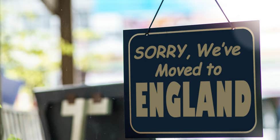 A sign hanging in a shop window, stating 'SORRY, We've Moved to ENGLAND'.