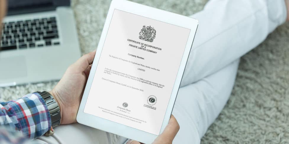 Person reading an iPad with screen displaying a certificate of incorporation.