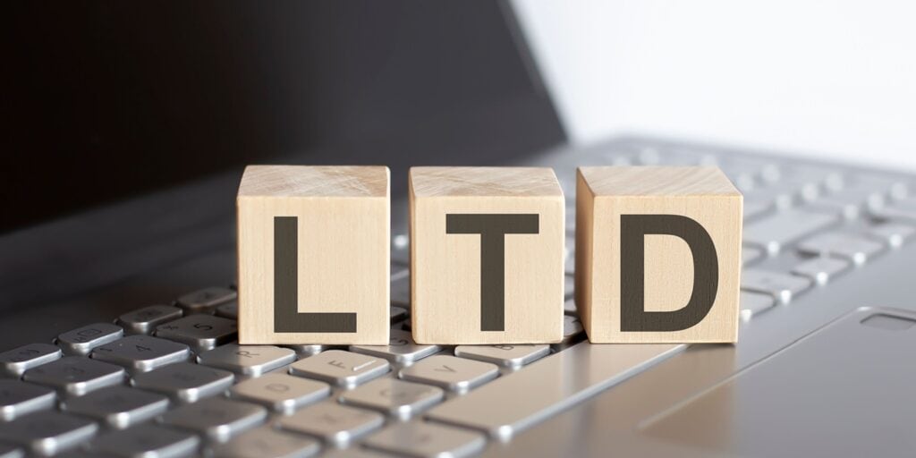 Wooden blocks spelling "LTD" placed on a laptop keyboard, symbolising the setup of a limited company