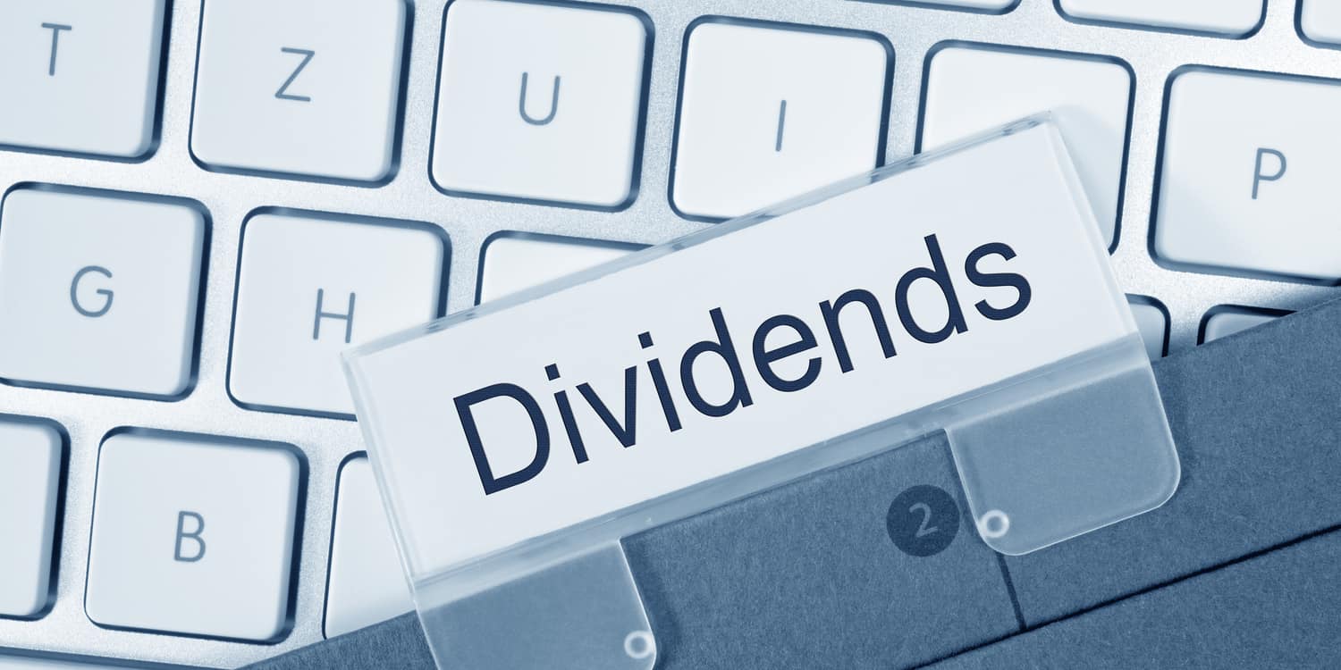assignment of right to receive dividends Cardboard file folder sitting on laptop keyboard, with plastic name tag displaying the word Dividends.