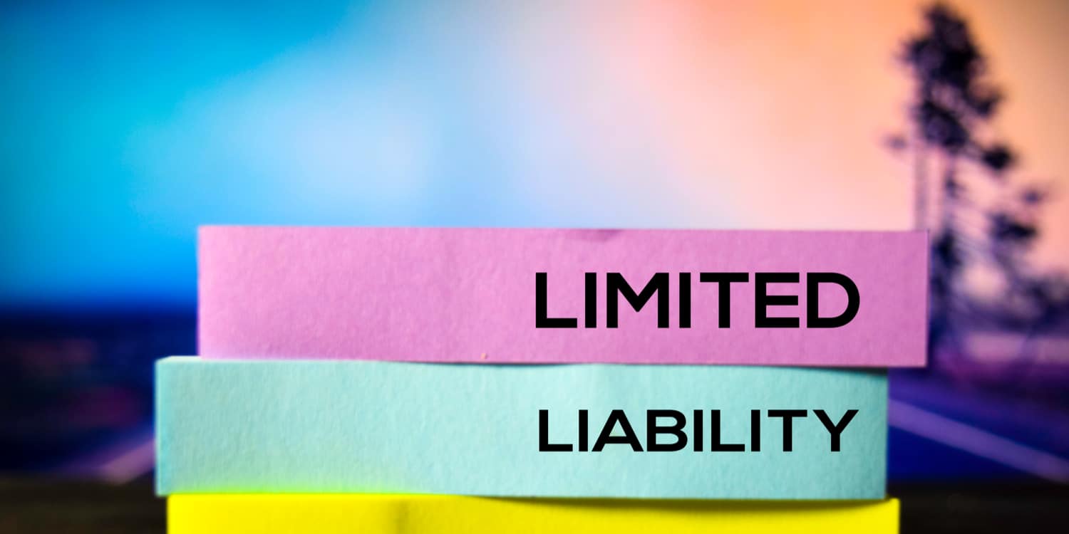 The words 'Limited' and 'Liability' in black font printed on coloured blocks with sky at sunset as a background.