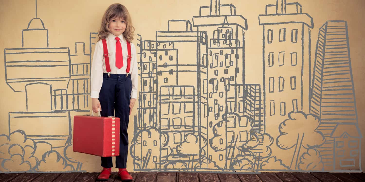 Child in suit standing next to mural of skyline