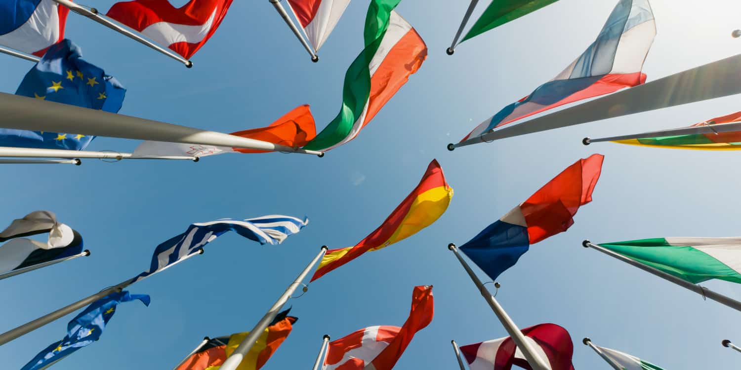 Photo of multiple national flags from the bottom looking up