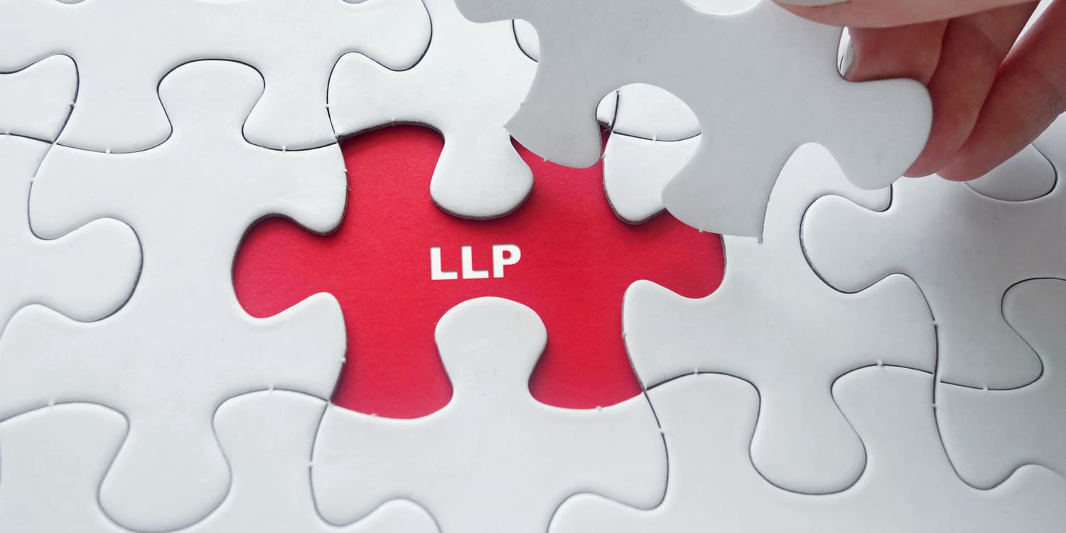White puzzle pieces, with one being removed to reveal a red background with LLP written on it