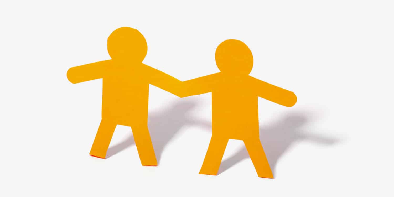 Yellow paper cut out of two people on a white background