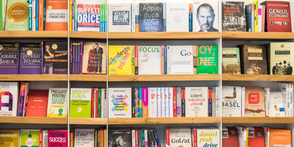 Bookshelves filled with various business and finance books, featuring colourful covers and bold titles.