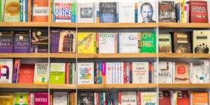 Bookshelves filled with various business and finance books, featuring colourful covers and bold titles.