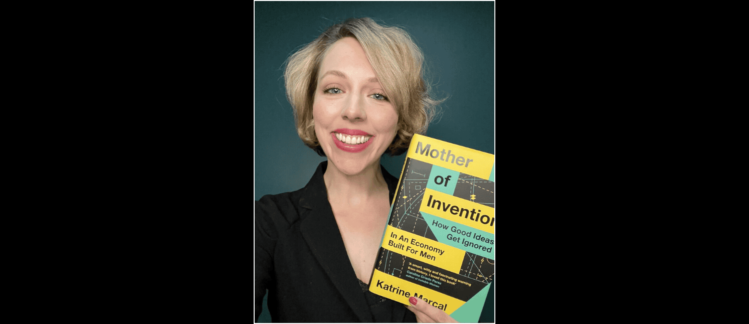 Author, Katrine Marçal, smiles whilst holding her book 'Mother of Invention'.