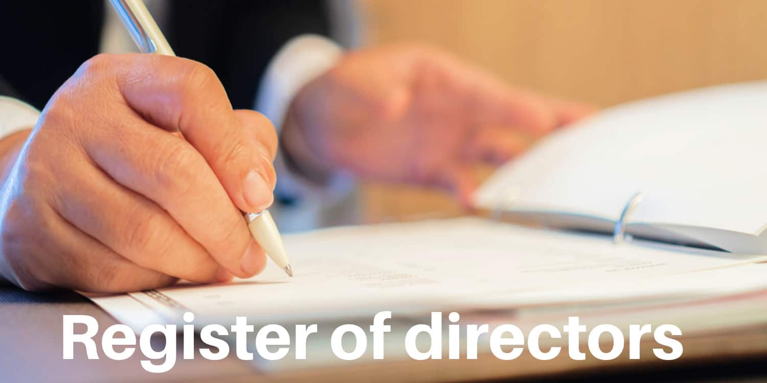 Businessman updating the register of directors with cream coloured ball point pen.
