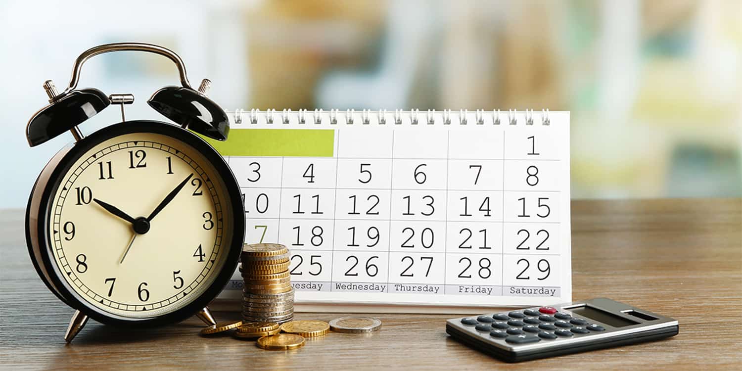 Photo of alarm clock, stacked coins, calendar and calculator - used to visualise HMRC's Time to Pay Scheme for Self Assessment customers