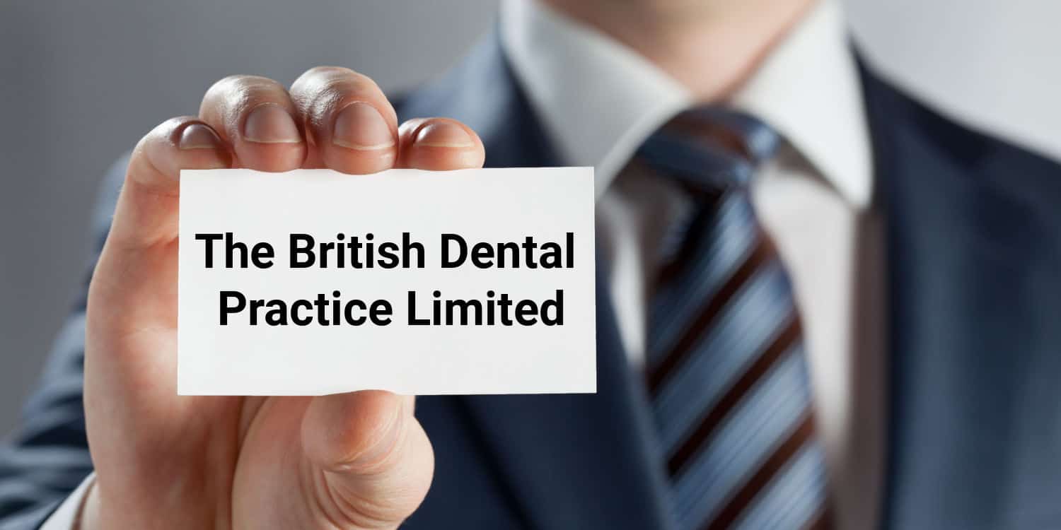 Man's hand showing business card displaying the company name - The British Dental Practice Limited.