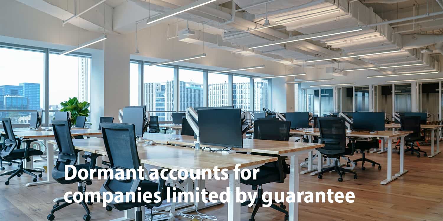 Interior of a modern empty office building with headline 'Dormant company accounts for companies limited by guarantee'.