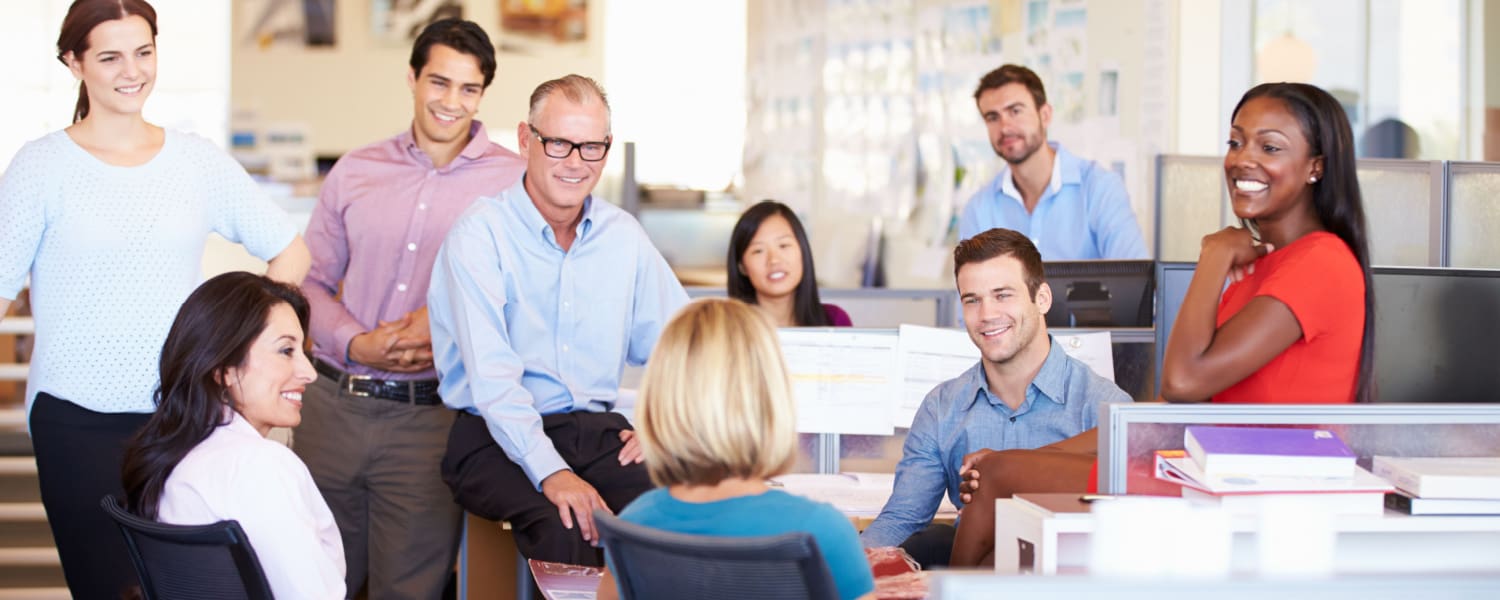 Group of office workers in a meeting in their open plan office.