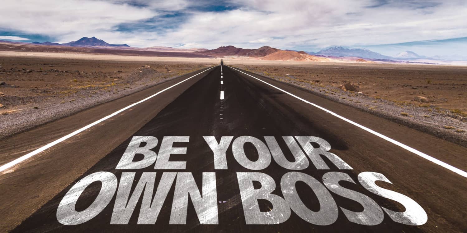 Be Your Own Boss written on desert road - disappearing into distant mountains.