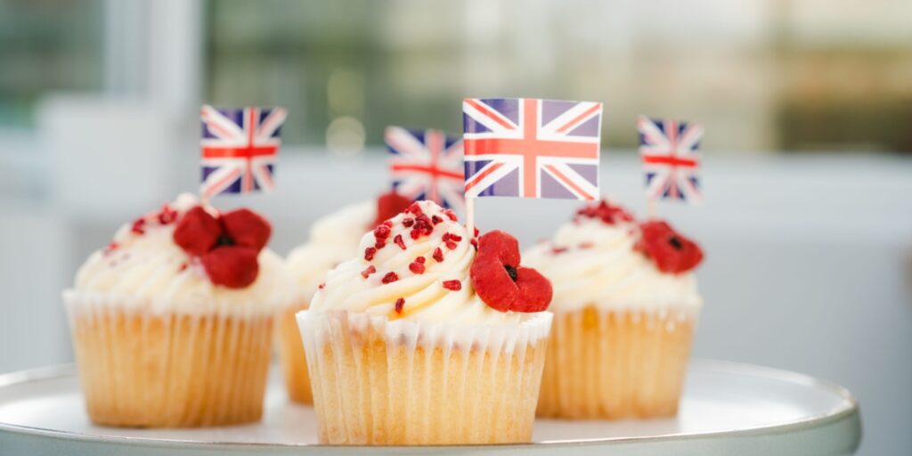 Plate of four vanilla cupcakes with butter icing and Union Jack flag decorations