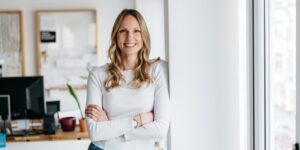 Business owner happily posing in her place of work. She's gone full time on her business.