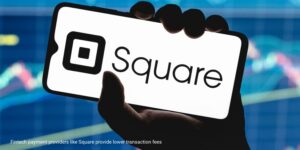 A male hand holding a smartphone with the Square logo on the screen.