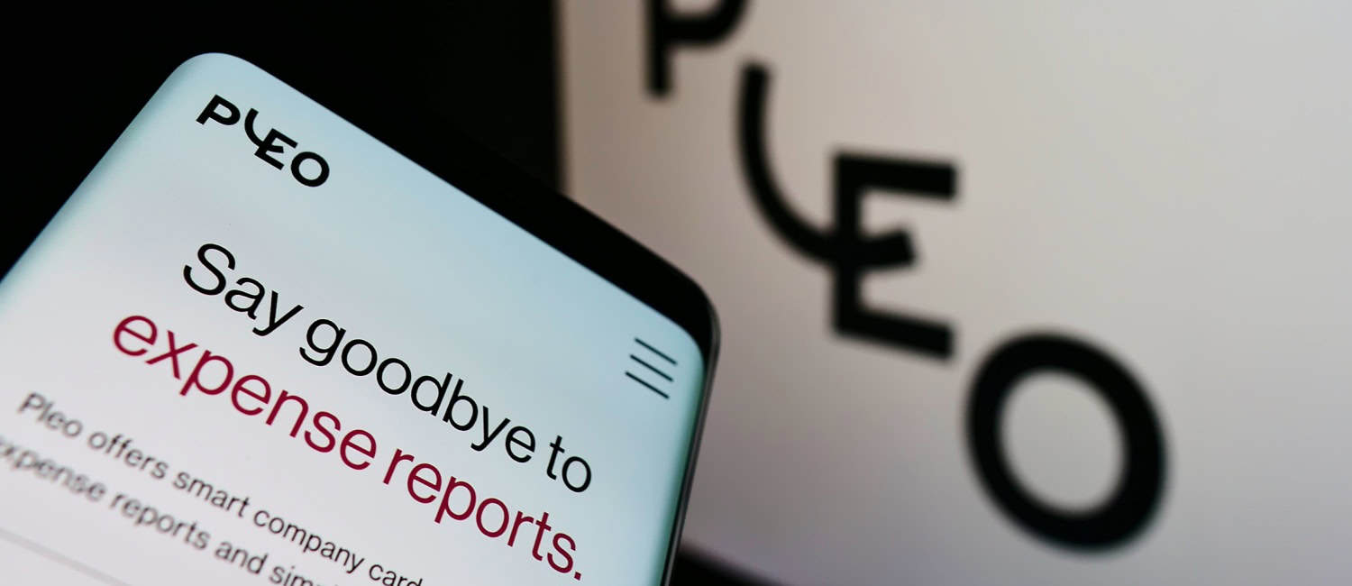 Smartphone with website of Danish fintech company Pleo Technologies on screen in front of business logo.