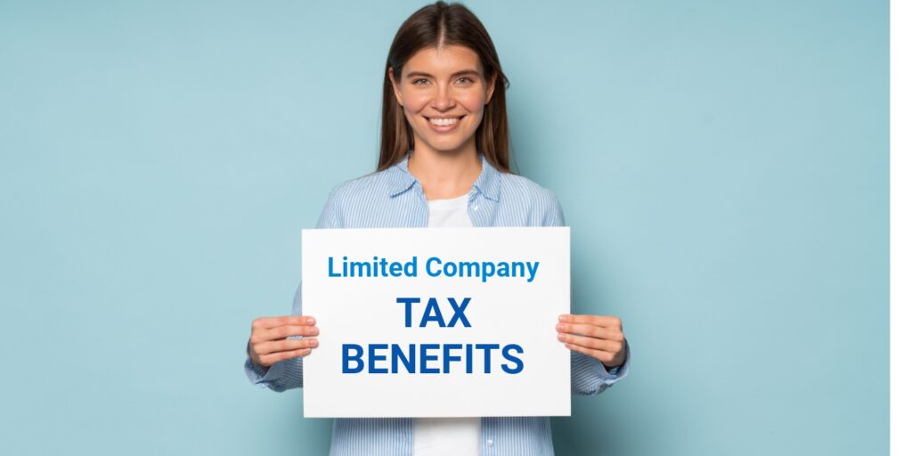 Smiling female business owner holding white banner displaying the words 'Limited Company TAX BENEFITS' in blue font, against a blue studio background.