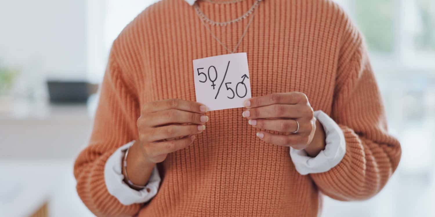 Gender equality, business woman holding a piece of paper illustrating 50-50 for equal funding in entrepreneuership.