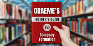 Person holding a red book titled "Graeme’s Insider’s Guide to Company Formation" in a library, referencing limited company setup