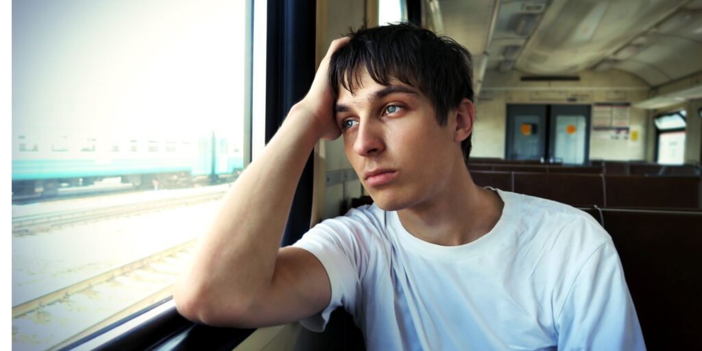 Sad teenager on a train contemplating the direction of his life and career.