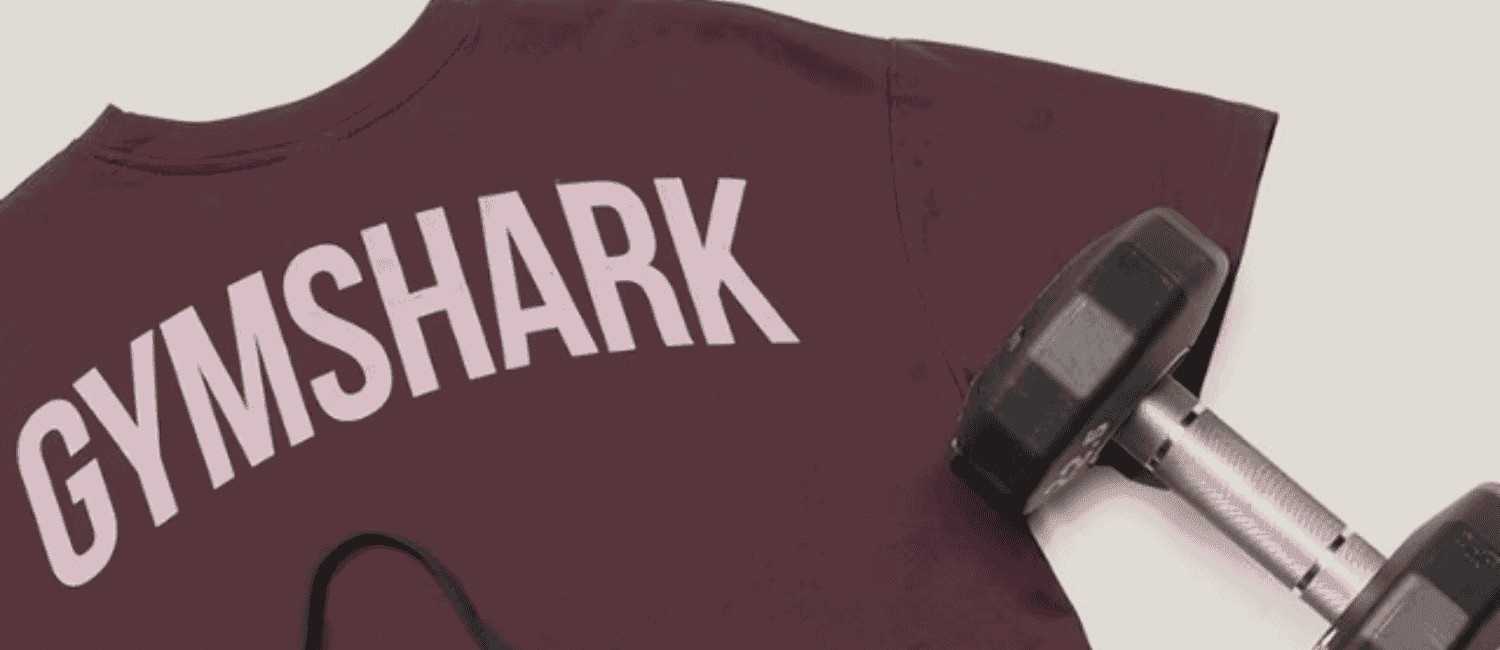 Burgundy GymShark t-shirt with dumbell and black GymShark sports bra.
