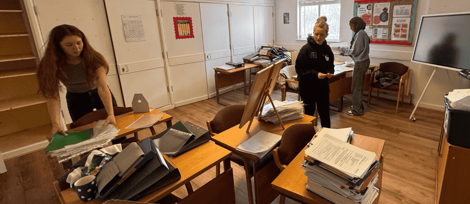 Group of 1st Formations employees tidying up a messy classroom.