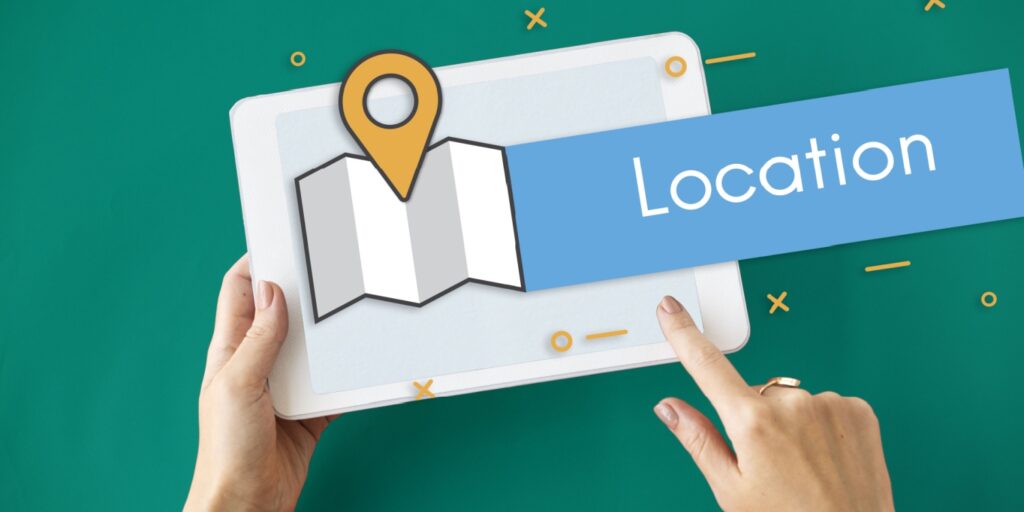 Person holding a tablet showing a map and location pin icon, representing the process to change registered office address for a business