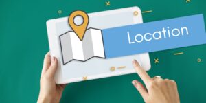 Person holding a tablet showing a map and location pin icon, representing the process to change registered office address for a business