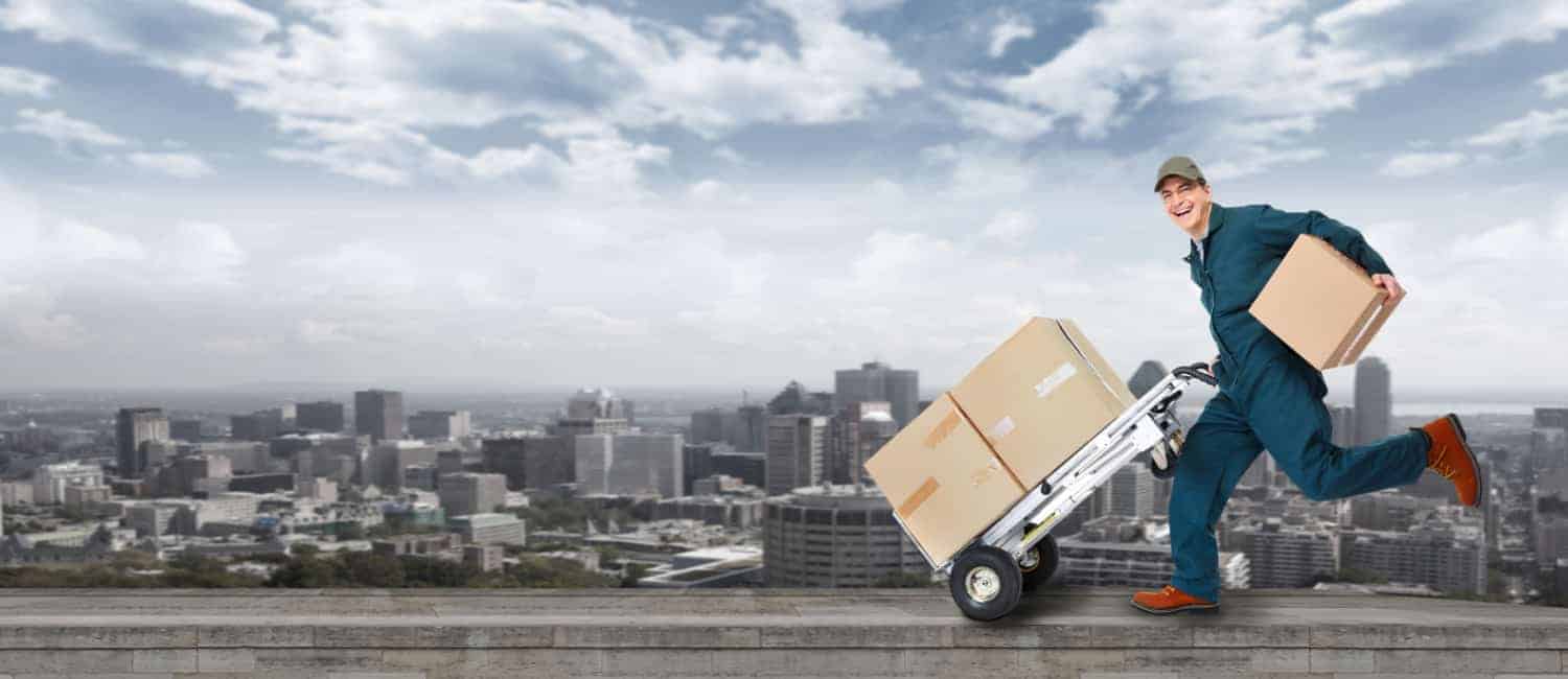 Running delivery man with blue overalls and brown boxes on a trolley.