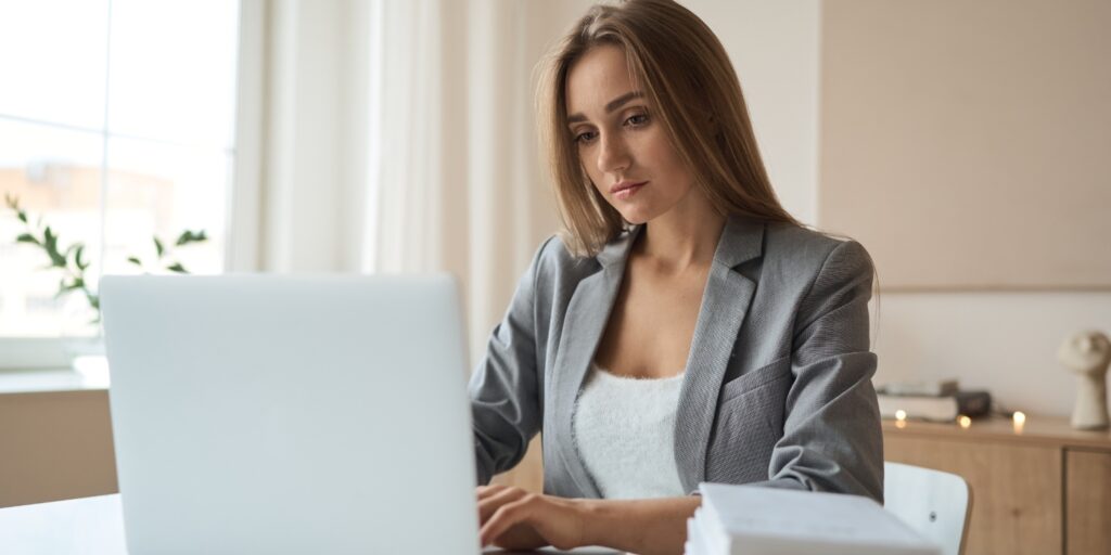 Businesswoman working on laptop in bright modern office