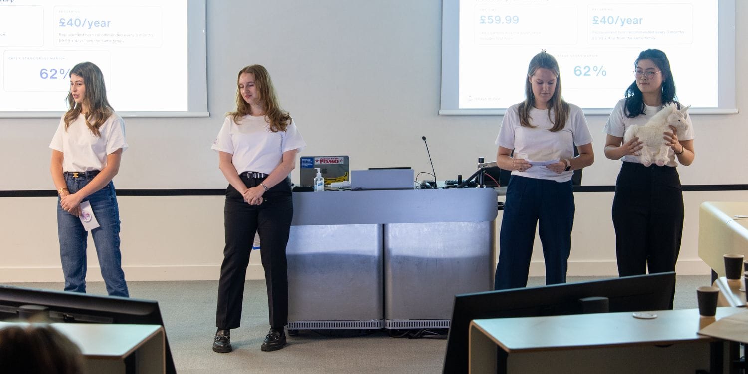 The Brave Buddy team delivering their pitch in front of the judges. The member on the right is holding a Brave Buddy unicorn.
