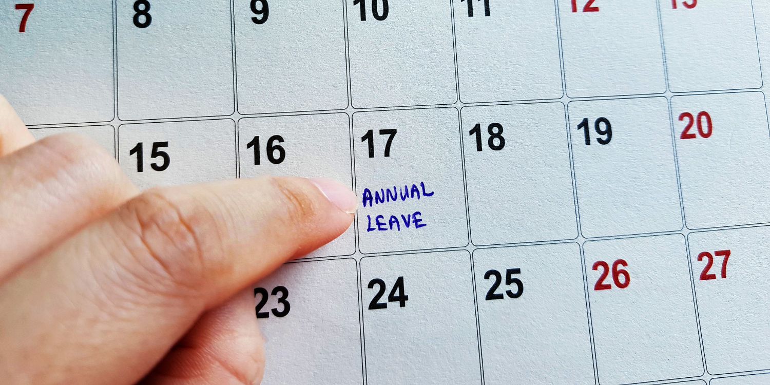 A finger pointing at a calendar, to the 17th of the month, where it says 'Annual Leave'.