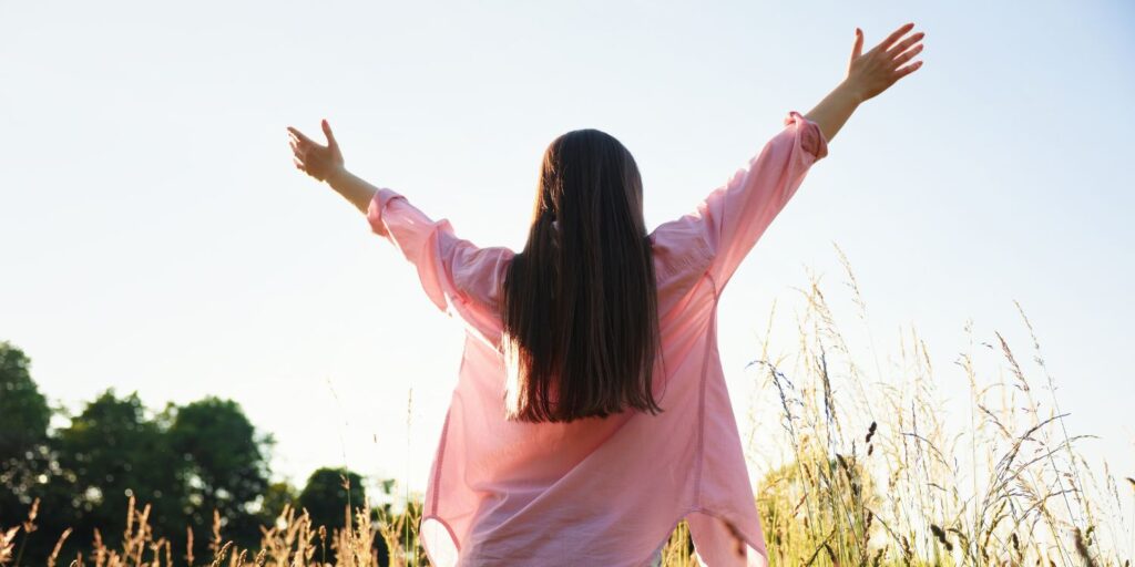 A woman enjoying time in nature, feeling freedom.